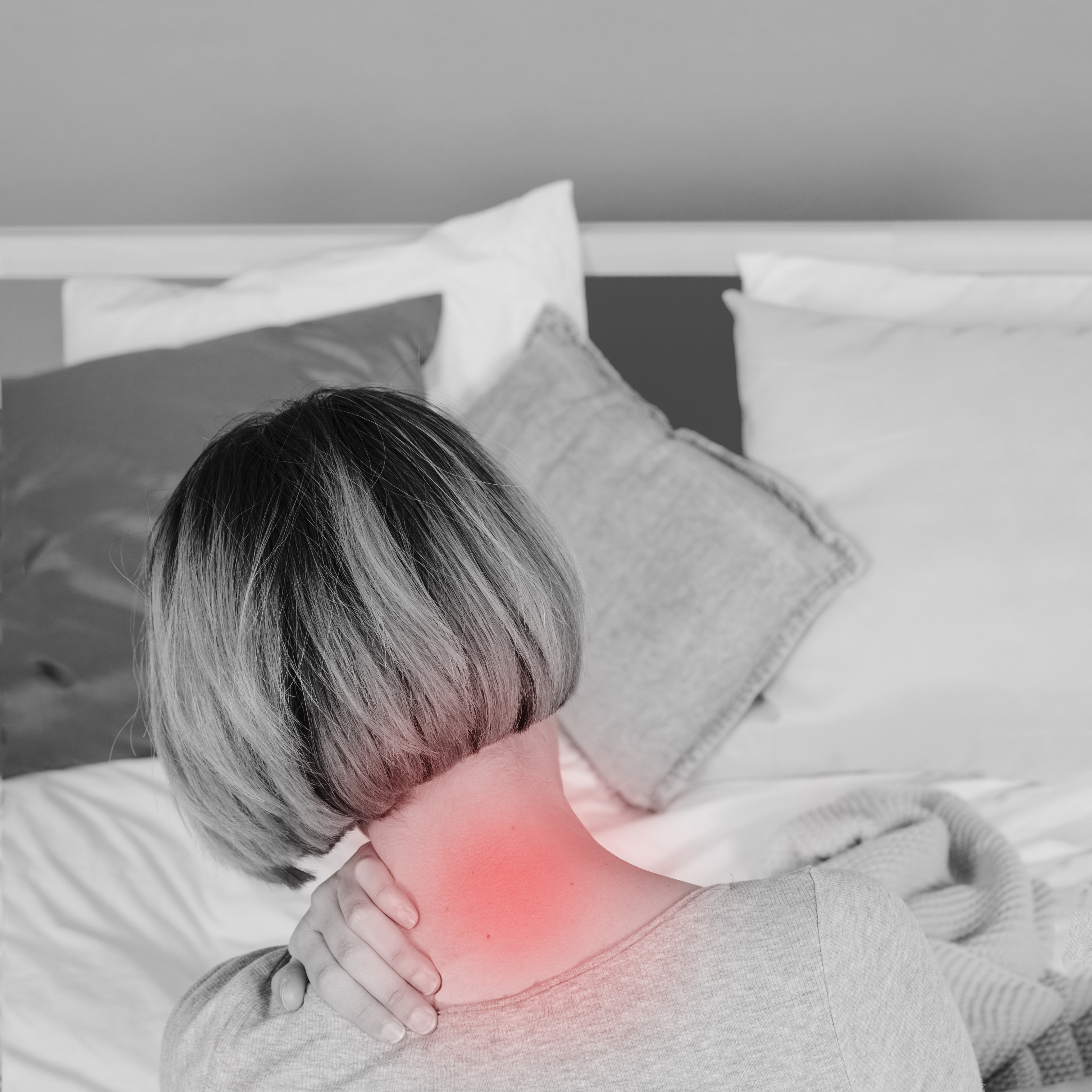 Femme souffrant de douleurs au cou, assise sur un lit